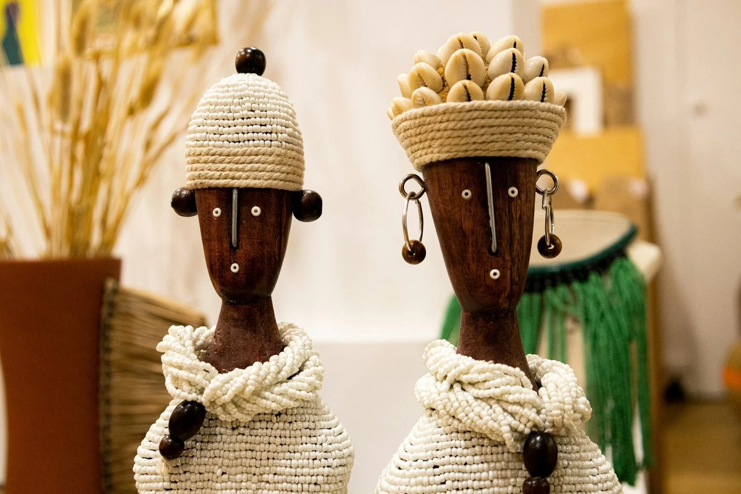 Two handcrafted African figures in textured white garments.