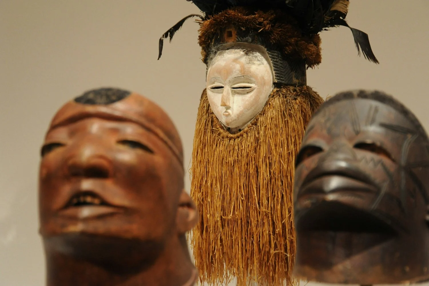 Three sculptural African masks and figures.